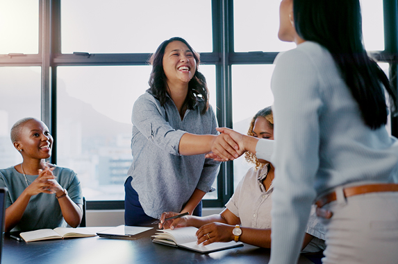 Women Shaking Hands in Conference Room